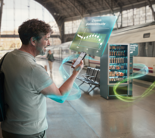 Henkilö tarkistaa glukoositasonsa puhelinsovelluksesta, joka näyttää glukoosilukemat ja ennustekaavion. Huomaamaton, jatkuva glukoosisensori on kiinnitetty hänen käsivarteensa.